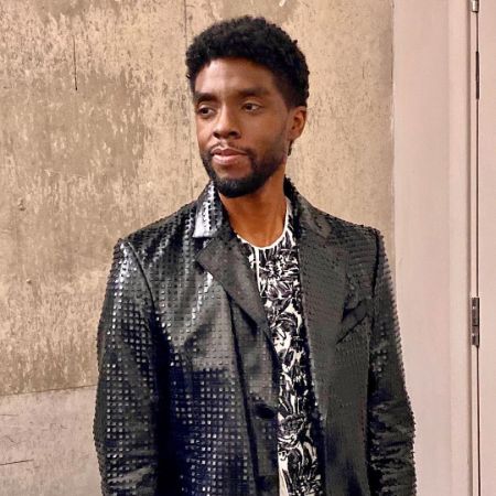 Chadwick Boseman is wearing a glittery black jacket.